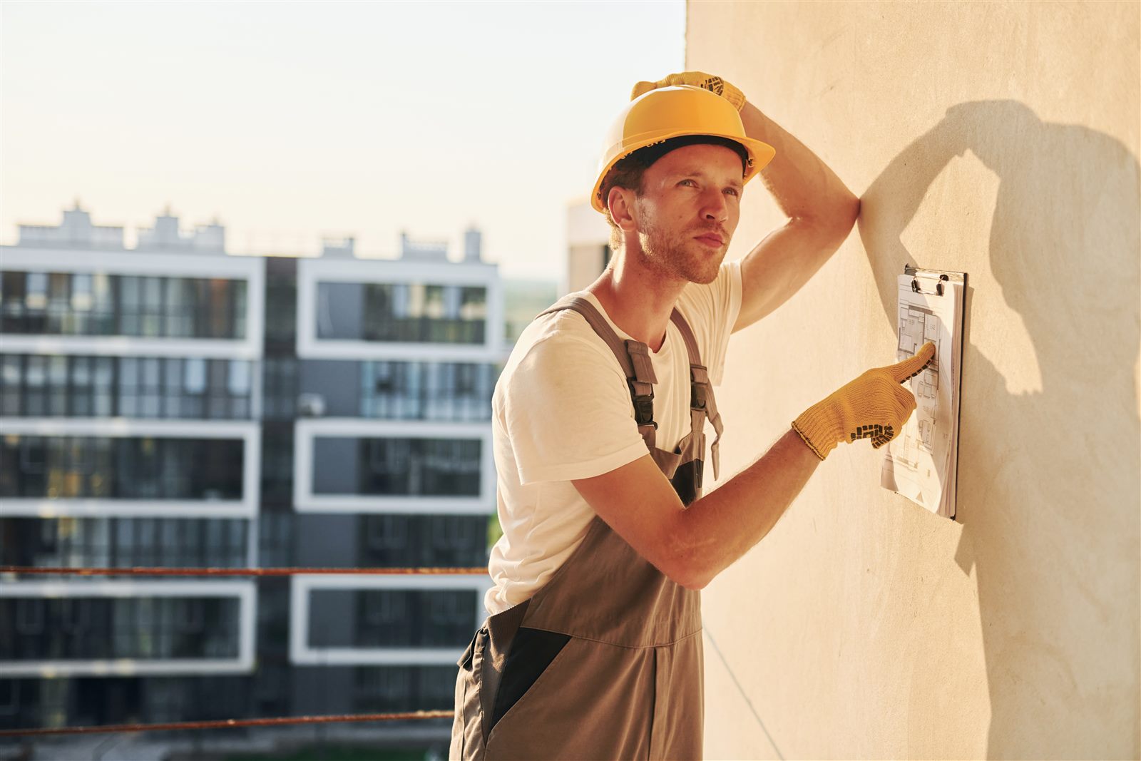 Artisan façadier sur échafaudage réalisant un ravalement de façade
